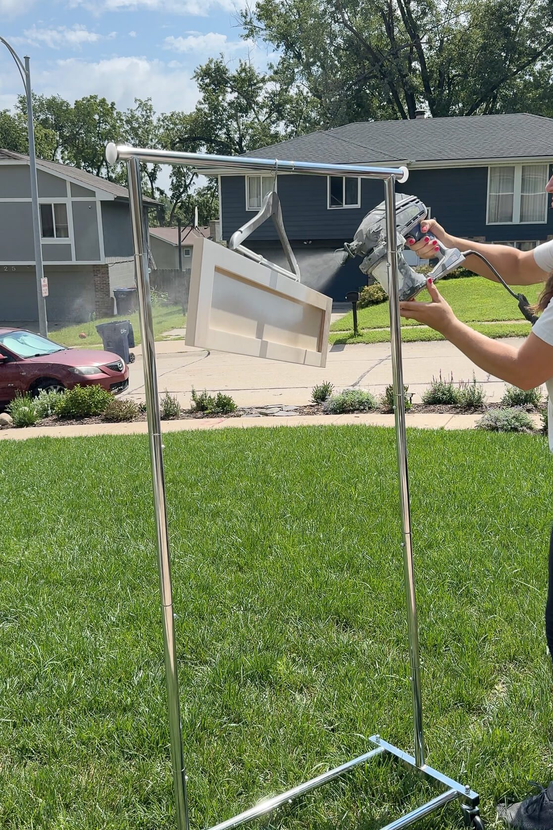 Painting drawer faces with a sprayer.